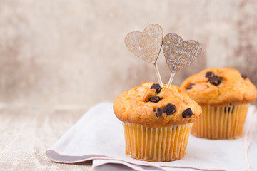 Homemade chocolate muffins with heart, vintage background.