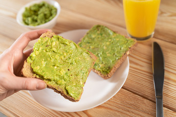 toast bread with guacamole on wooden cutting board - close up