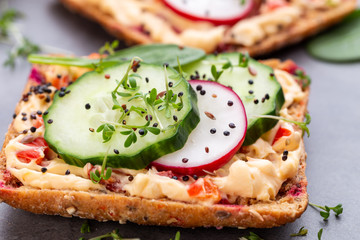 Sandwiches with cream cheese, vegetables and salami.