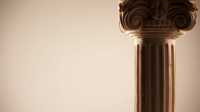 Single ancient corinthian column rotating slowly on bright background