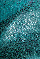 abstract metal texture. Macro view of bumpy blue-silver fabric surface with metallic effect