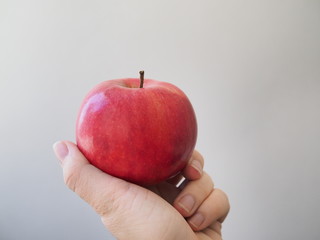 Big ripe red Apple in hand on bright background