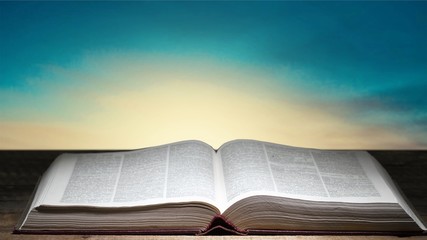 Open book on old wooden table.