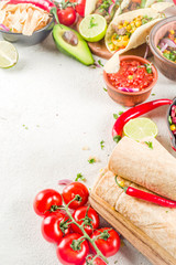 Cinco de Mayo food.Mexican food concept background with taco, quesadilla, burrito, chili, salsa sauce, hot pepper, lime. Black concrete background top view copy space