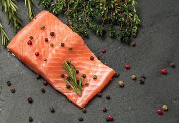 Raw salmon, trout fillet on a dark slate background. Wild atlantic fish. Healthy food.