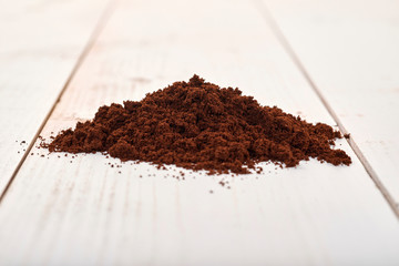 Ground coffee isolated on a wooden table