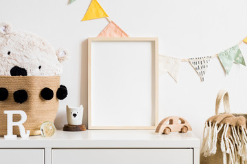 Stylish scandinavian nursery interior with  white teddy bear, wooden toys and cup. Hanging cotton...