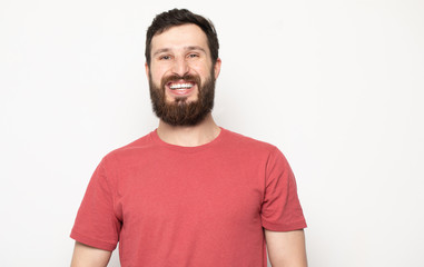 Obraz premium Portrait of young amazed bearded man isolated on gray background