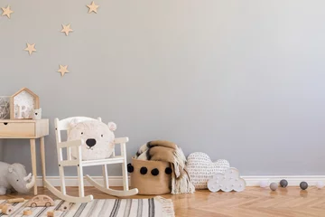 Fototapeten Stylish scandinavian newborn baby room with toys, teddy bear on children's chair, natural basket with blanket. Modern interior with grey background walls, wooden parquet and stars pattern. Real photo. © FollowTheFlow