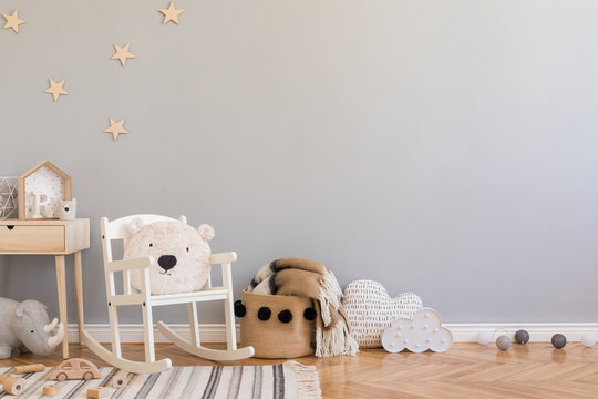 Stylish Scandinavian Newborn Baby Room With Toys, Teddy Bear On Children's Chair, Natural Basket With Blanket. Modern Interior With Grey Background Walls, Wooden Parquet And Stars Pattern. Real Photo.