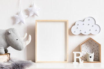 The modern scandinavian newborn baby room with mock up photo frame, wooden toy, plush rhino and...