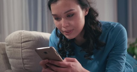 Happy woman text messaging on mobile phone at home