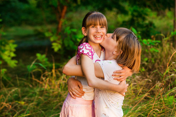 Little girl is very happy that she has sister. Loving sister hugging cute little girl showing love care support. Sincere warm relationships. Concept of happy family, adoption, foster sister.