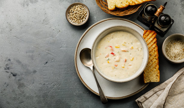 Chowder Crab Soup with shrimps and corn on concrete background copy space