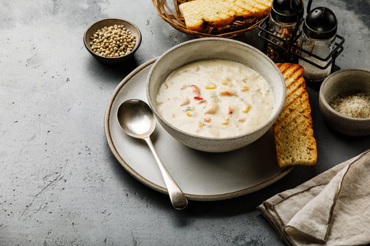 Chowder Crab Soup with shrimps and corn on concrete background copy space