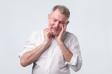 Obraz premium Sad senior man in white shirt thinking abour life.