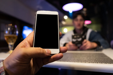 man using digital phone in cafe
