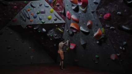 Athletic man practicing in a bouldering gym