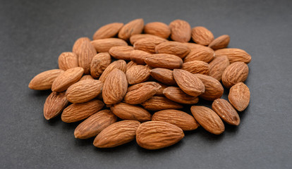 Pile of almon on dark background.