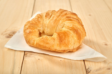 Fresh baked croissants on wooden table