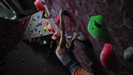 Athletic woman practicing in a bouldering gym