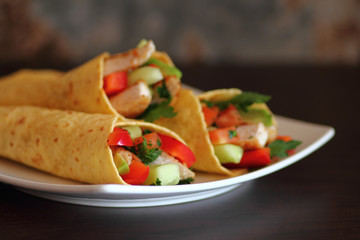 Fresh chicken and salad tortilla wraps on white plate