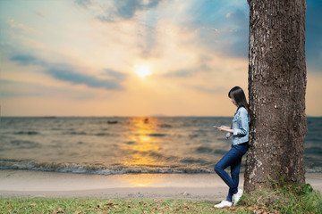Fototapeta premium Women are playing smart phone on the beach.