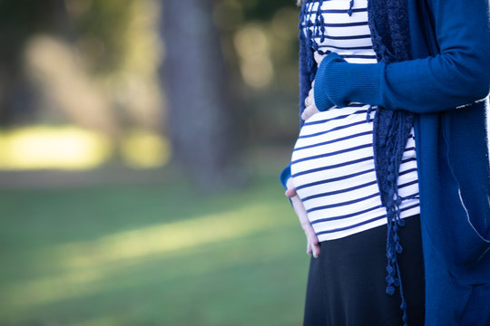 Mulher gr&aacute;vida com camisola azul &aacute;s riscas