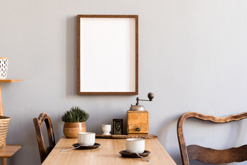 Retro and stylish interior of kitchen space with small wooden table with brown mock up photo frame,...