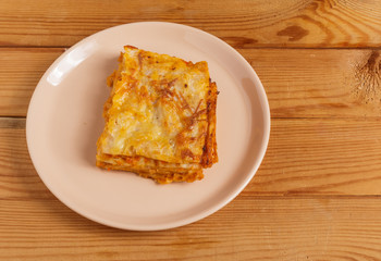 A piece of lasagna on a plate on the table.