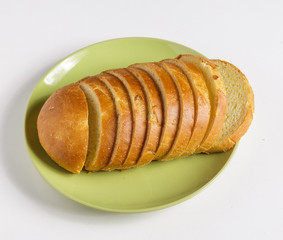 Wheat bread slices on a plate on a white background.