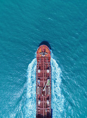 Aerial top view Oil ship tanker full speed with beautiful wave transportation from refinery on the sea.