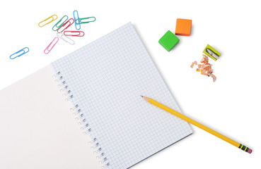 Yellow pencil, grid notepad, colored erasers, pencil sharpener and paper clips isolated on white background. School or office stationery.