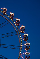 Fragment of ferris wheel in the evening lighting