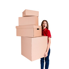 Shocked woman is looking at a heap of boxes with a widely open mouth isolated on white background