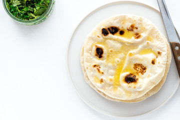 Flat traditional bread on a white background. Top view, copy space.