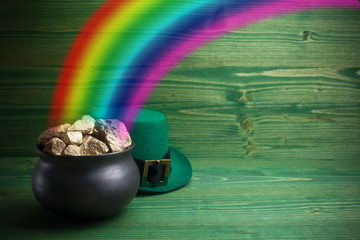Pot Of Gold on green woden background. Magical Treasure with Rainbow