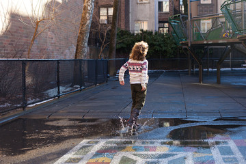 Girl jumping puddle