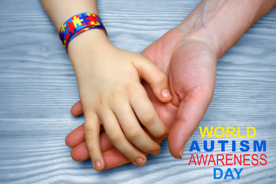 Autism Awareness Picture. Father holding hand his autistic child