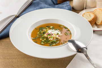 Summer cold soup okroshka with radish, cucumber and dill on wooden table