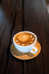 Latte art coffee cup on wooden table