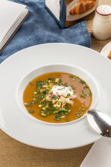 Summer cold soup okroshka with radish, cucumber and dill on wooden table
