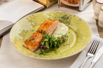 Grilled Salmon with fresh salad and mashed potatoes on wooden table