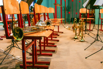 background of the concert hall and wind instruments on the stage lying on the chairs and on the floor