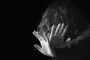 Violence against women. Black and white portrait of scared and desperate woman, focus on the hands...