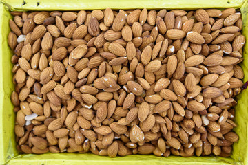 Background of raw almonds in yellow box