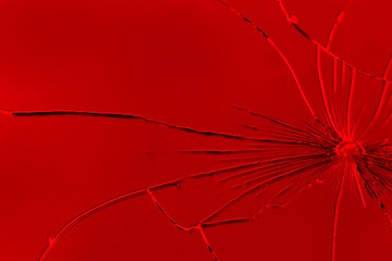 Large cracks on the texture of a broken mirror, glass on a bright red background