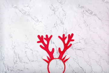 Antlers of a deer headband on marble background. Pair of toy reindeer horns on white marble texture