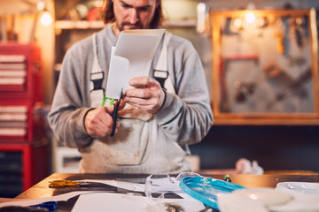 Male carpenter fixing old wood in a retro vintage workshop.