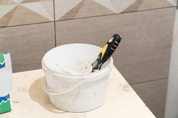 A bucket of putty for tile joints. Finishing works. The technology of laying tile. © warloka79